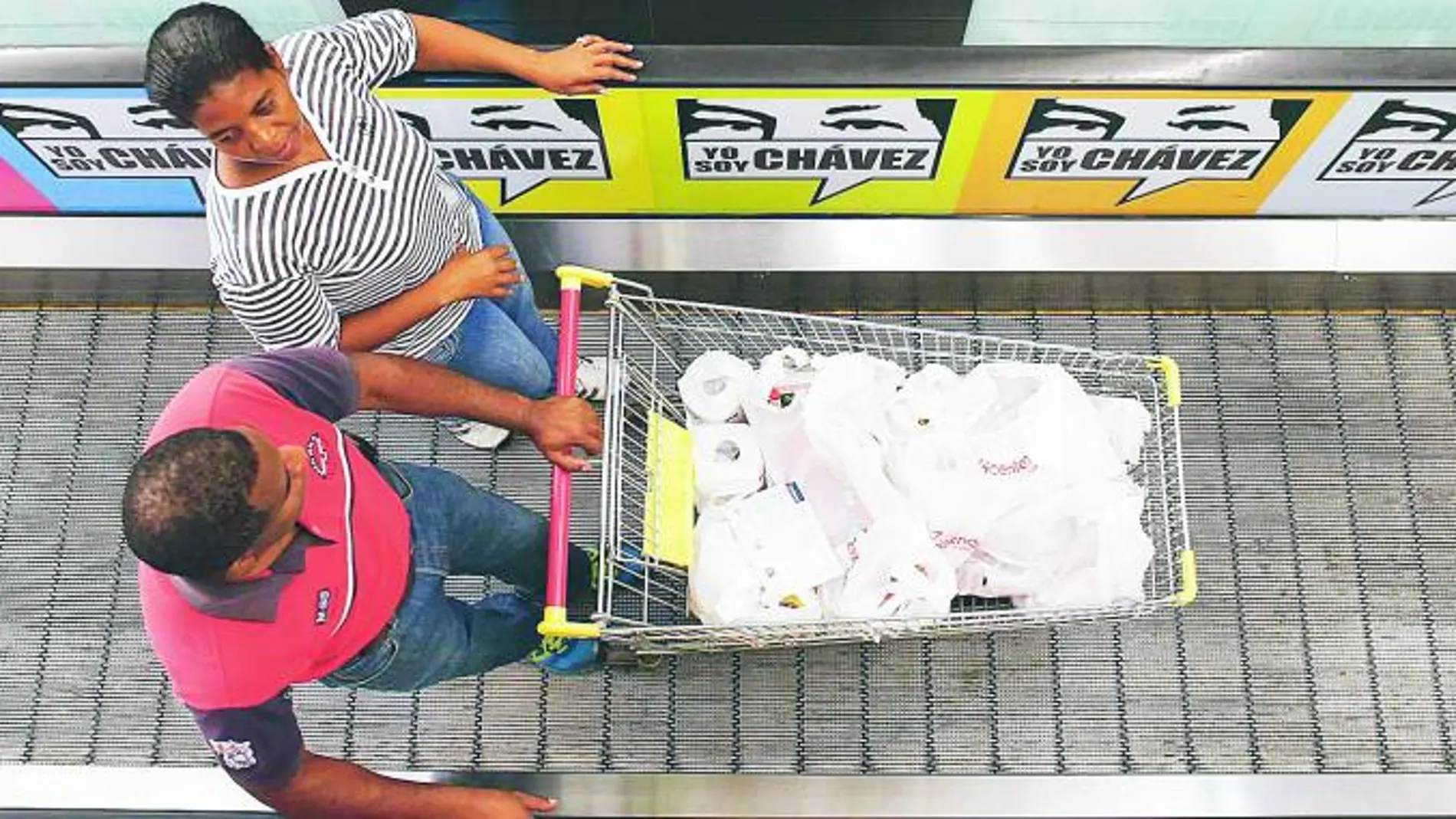 Una pareja sale del supermercado estatal «Bicentenario», después de unas compras en Caracas