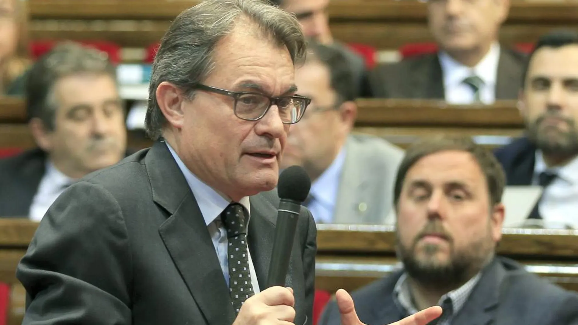 El presidente de la Generalitat, Artur Mas, responde a una pregunta ante la mirada del líder de ERC, Oriol Junqueras