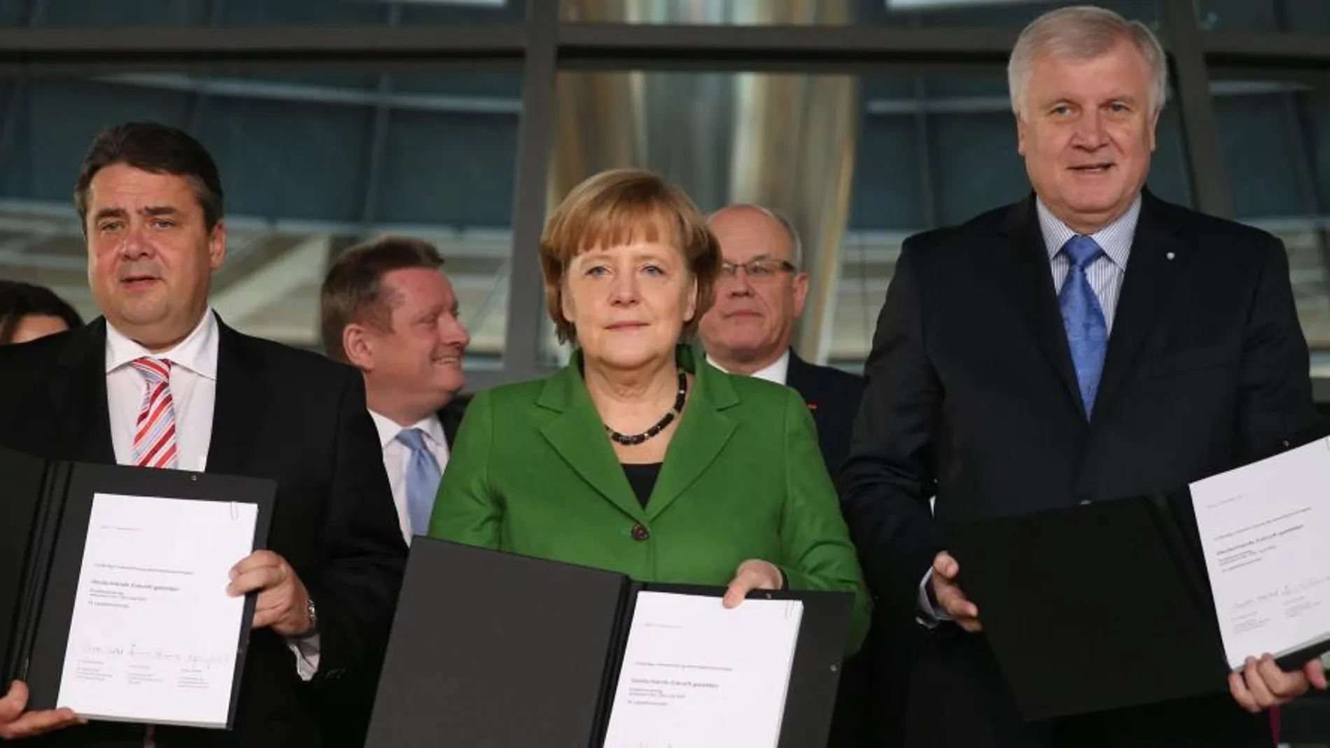El presidente del SPD, Sigmar Gabriel; la canciller alemana de la CDU, Angela Merkel; y el presidente de la Unión Socialcristiana (CSU), Horst Seehofer, posan tras firmar un acuerdo de gran coalición de gobierno en el histórico edificio del Reichstag, en Berlín (Alemania).