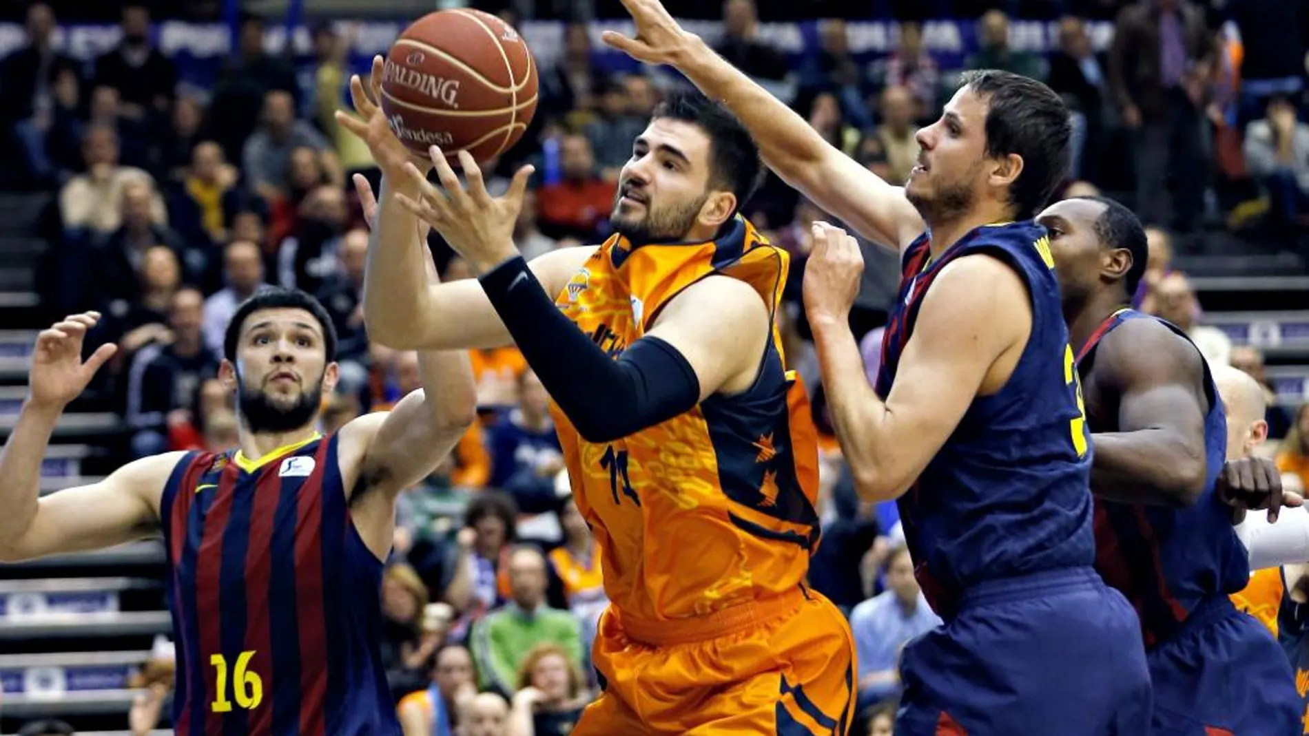 El ala pivot montenegrino del Valencia Basket Bojan Dubljevic intenta superar la defensa del alero esloveno del Barcelona Bostjan Nachbar