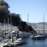 Vista del incendio del yate deportivo de unos 20 metros de eslora que se ha producido hoy en el puerto de Punta Lagoa, en Vigo
