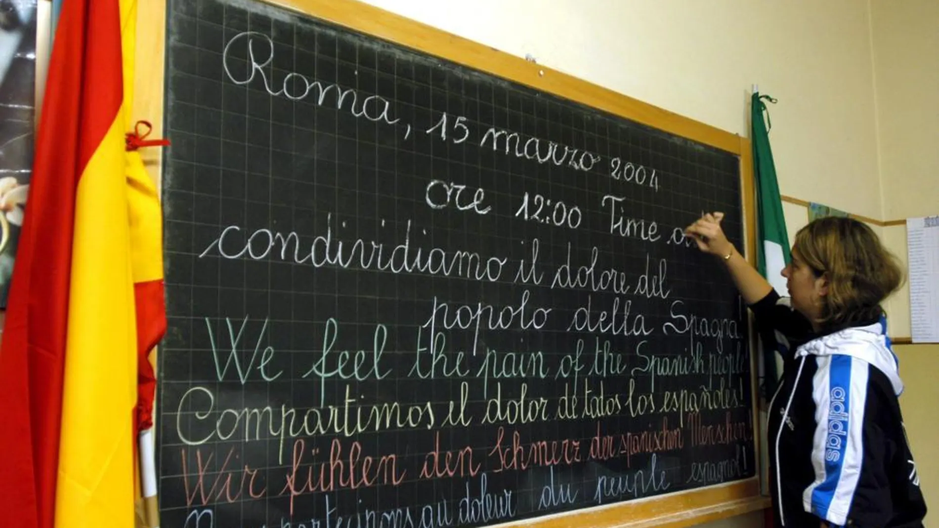 Un estudiante de secundaria escribe en una pizarra en italiano, español, inglés,a lemán y francés en recuerdo a los españoles por los atentados del 11-M