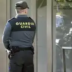 Varios agentes de la Guardia Civil custodian la entrada a la sede del gestor de infraestructuras ferroviarias de Adif en Madrid.