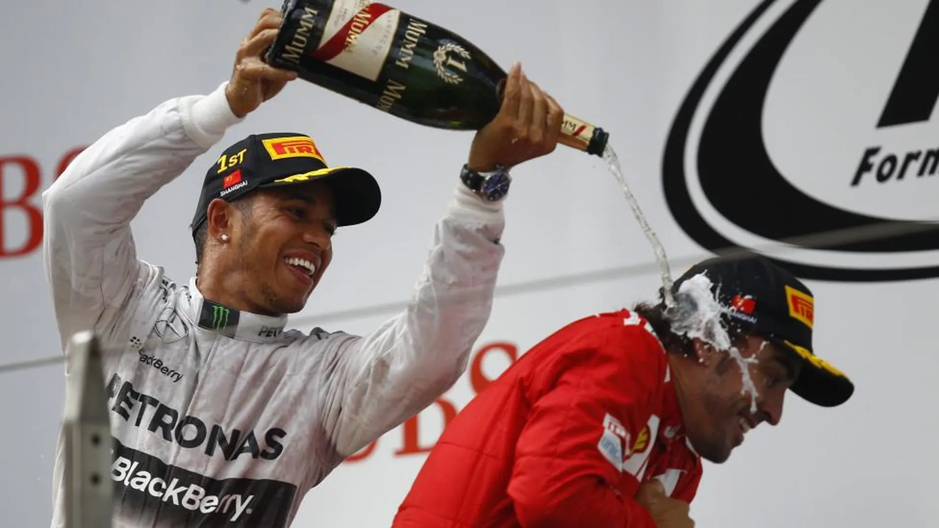 Lewis Hamilton rocía con champán a Fernando Alonso