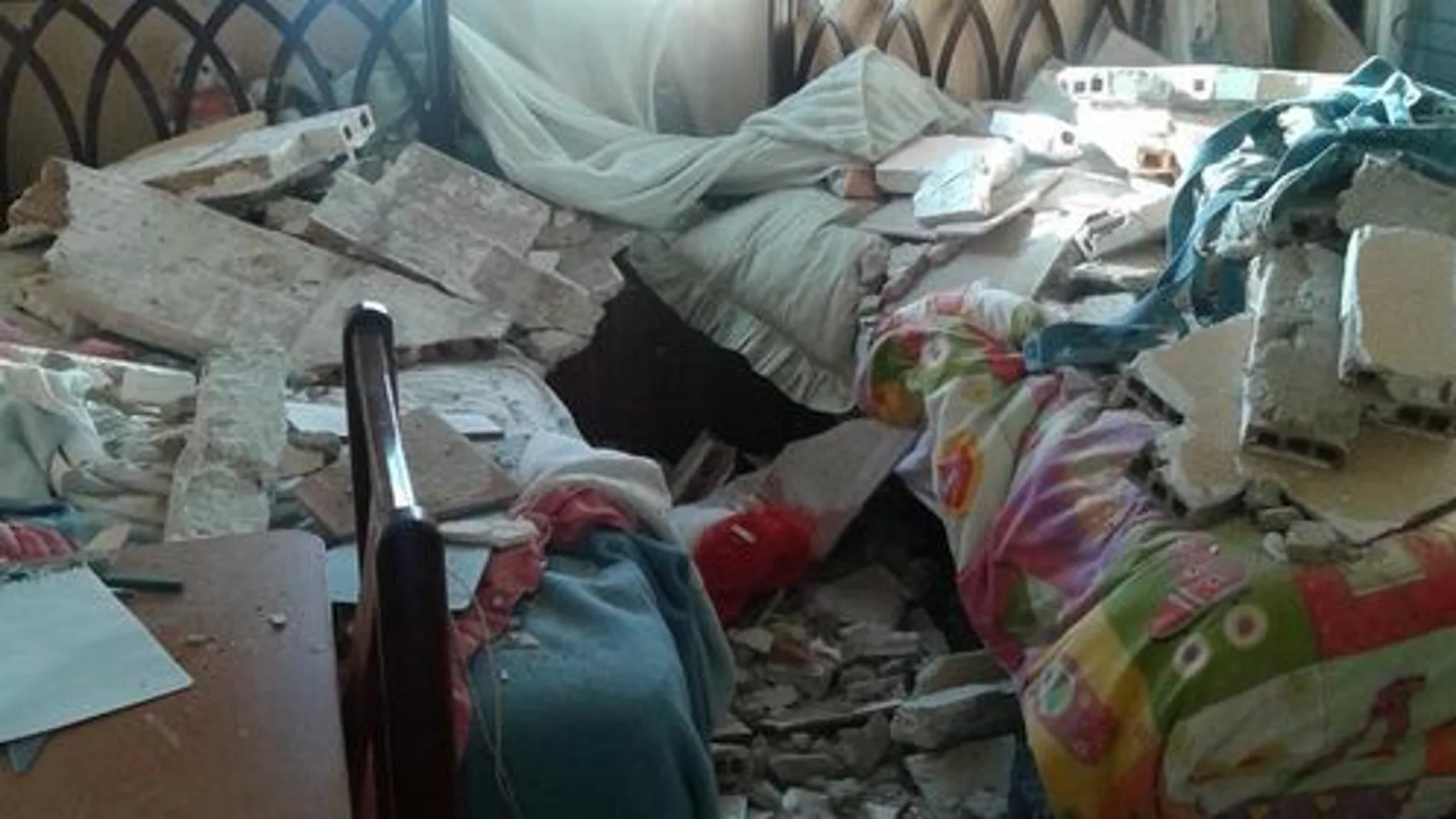 Imagen de una de las habitaciones afectadas con las camas llenas de escombros.