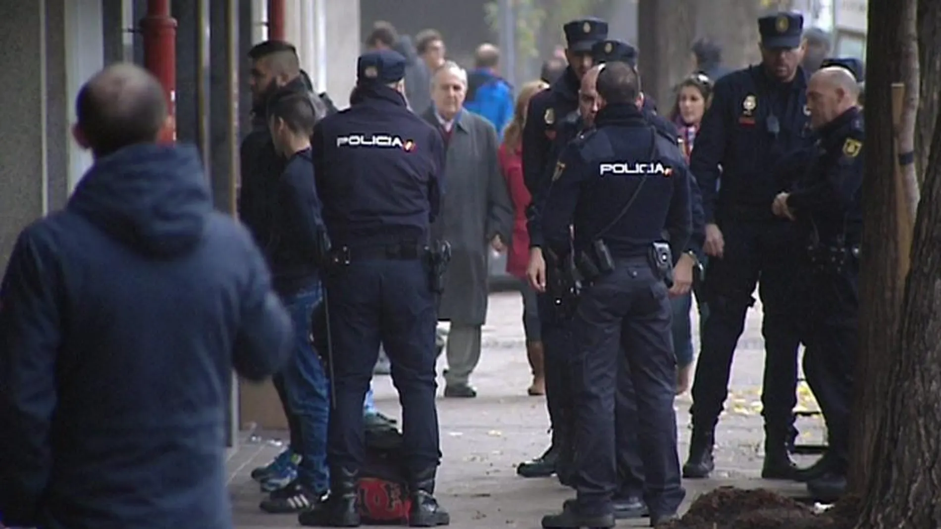 Imagen de televisión de efectivos de la Policía Nacional con algunos de los 21 detenidos en la reyerta en Madrid Río.