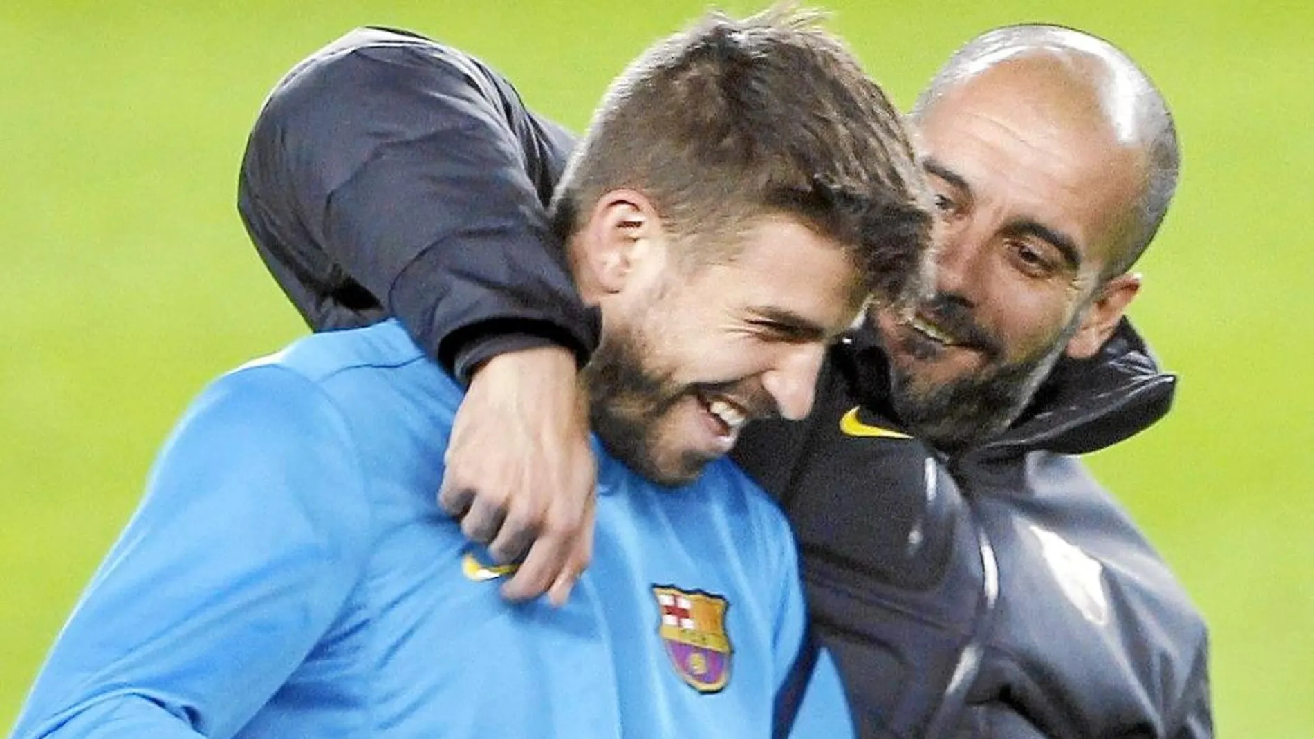 Piqué y Guardiola se abrazan durante un entrenamiento