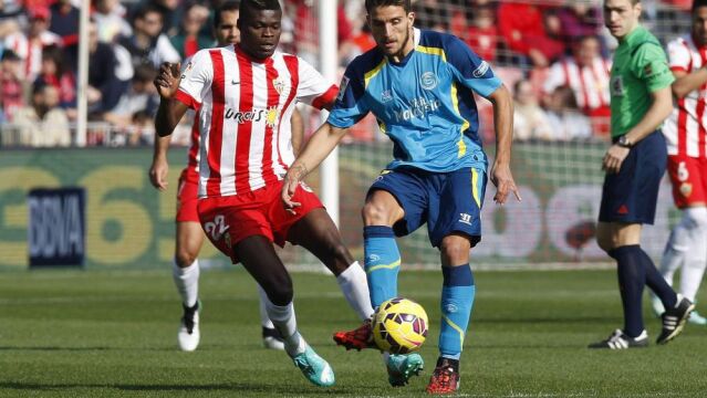 El centrocampista portugués del Sevilla, Daniel Carriço (c), controla un balón ante el centrocampista ghanés del Almería, Thomas Partey (i).