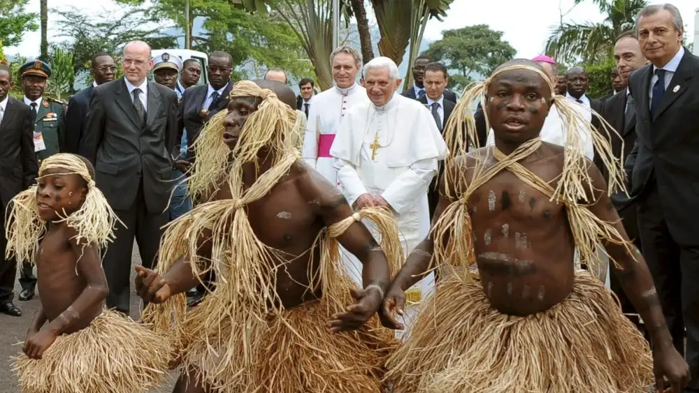 Tres pigmeos bailan en presencia del Papa Benedicto XVI, en una visita del pontífice a Camerún