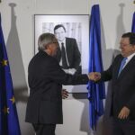 Jose Manuel Durao Barroso estrecha la mano del nuevo presidente, Jean-Claude Juncker.