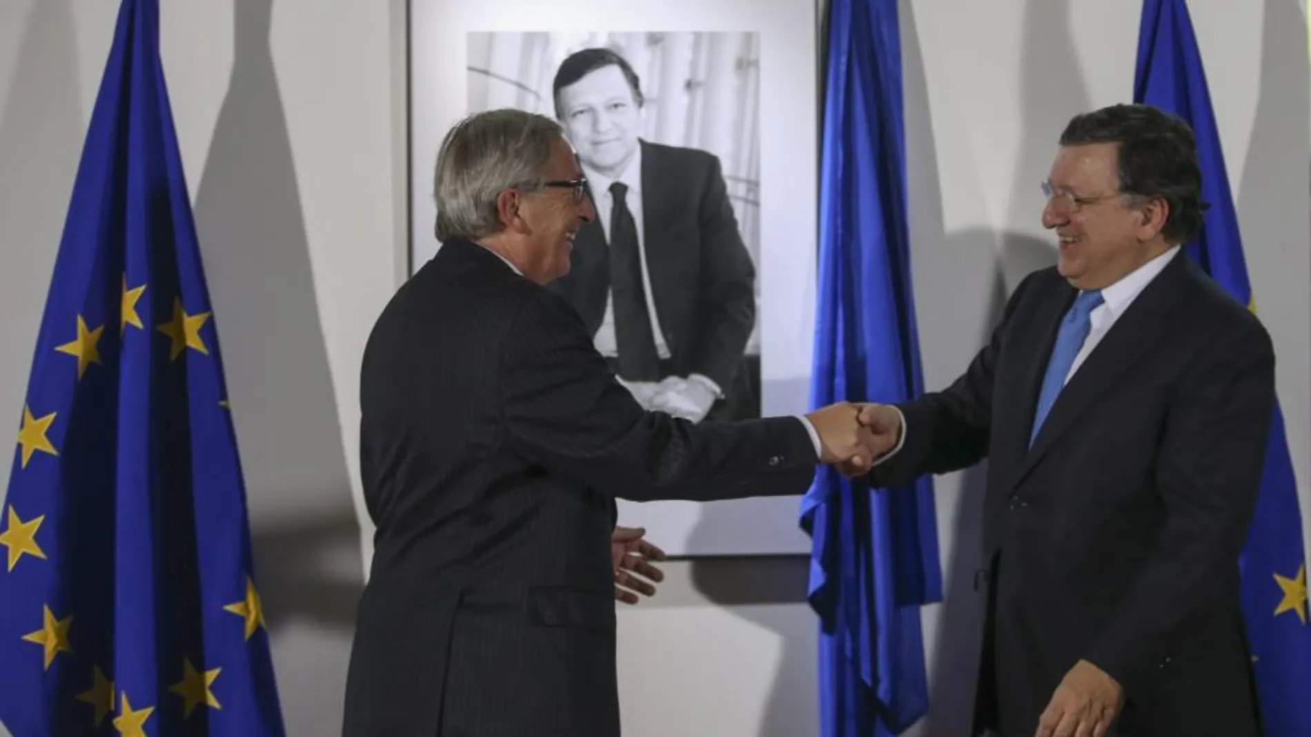 Jose Manuel Durao Barroso estrecha la mano del nuevo presidente, Jean-Claude Juncker.