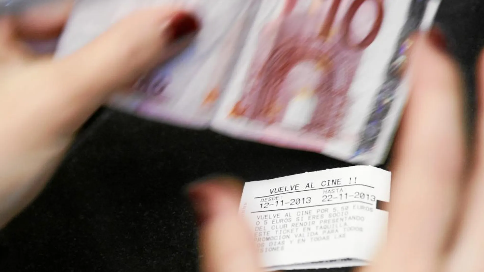 Un espectador paga la entrada en un complejo de cines del centro de Madrid