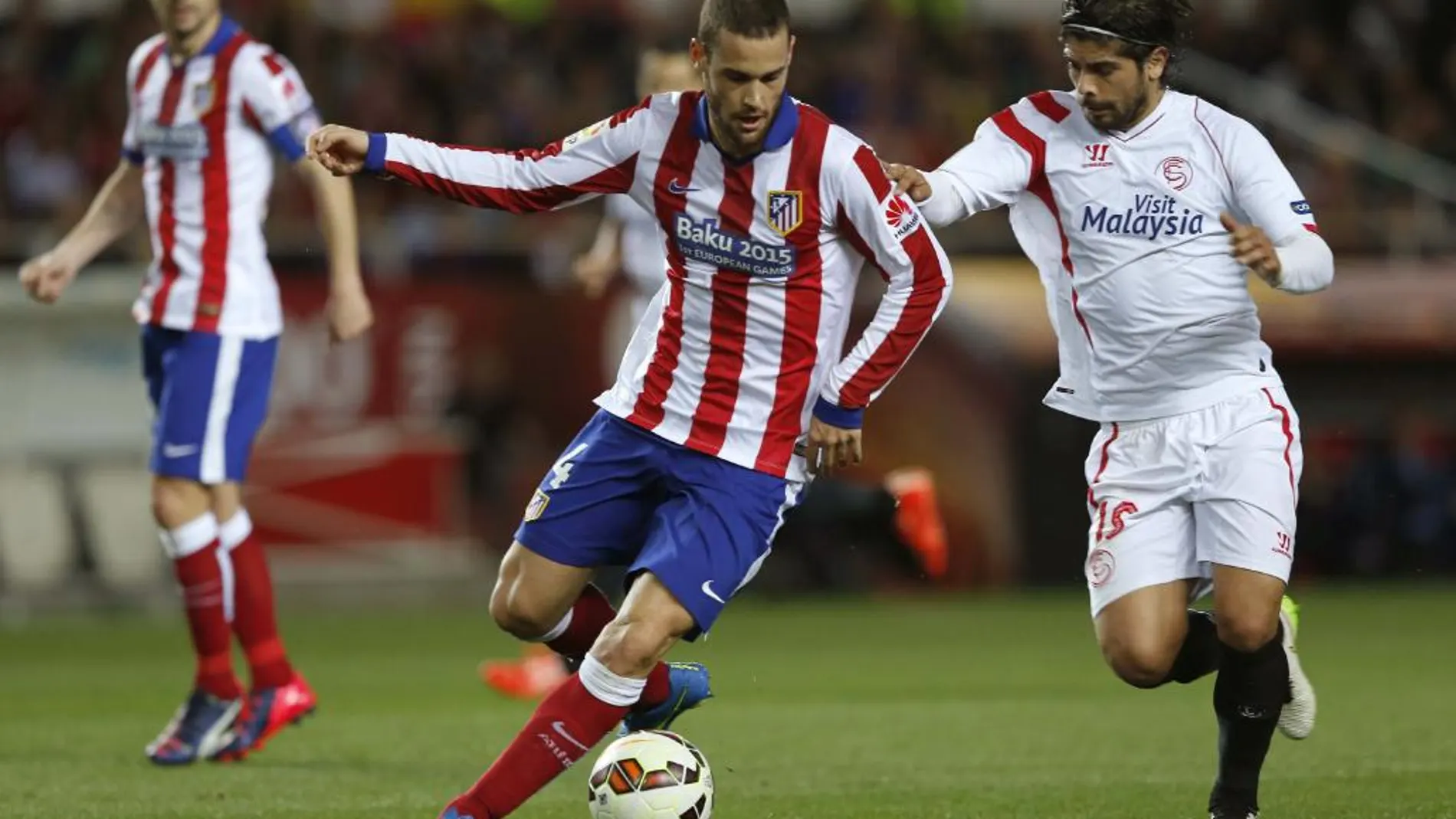 El centrocampista argentino del Sevilla Éver Banega intenta arrebatar el balón al centrocampista del Atlético de Madrid Mario Suárez