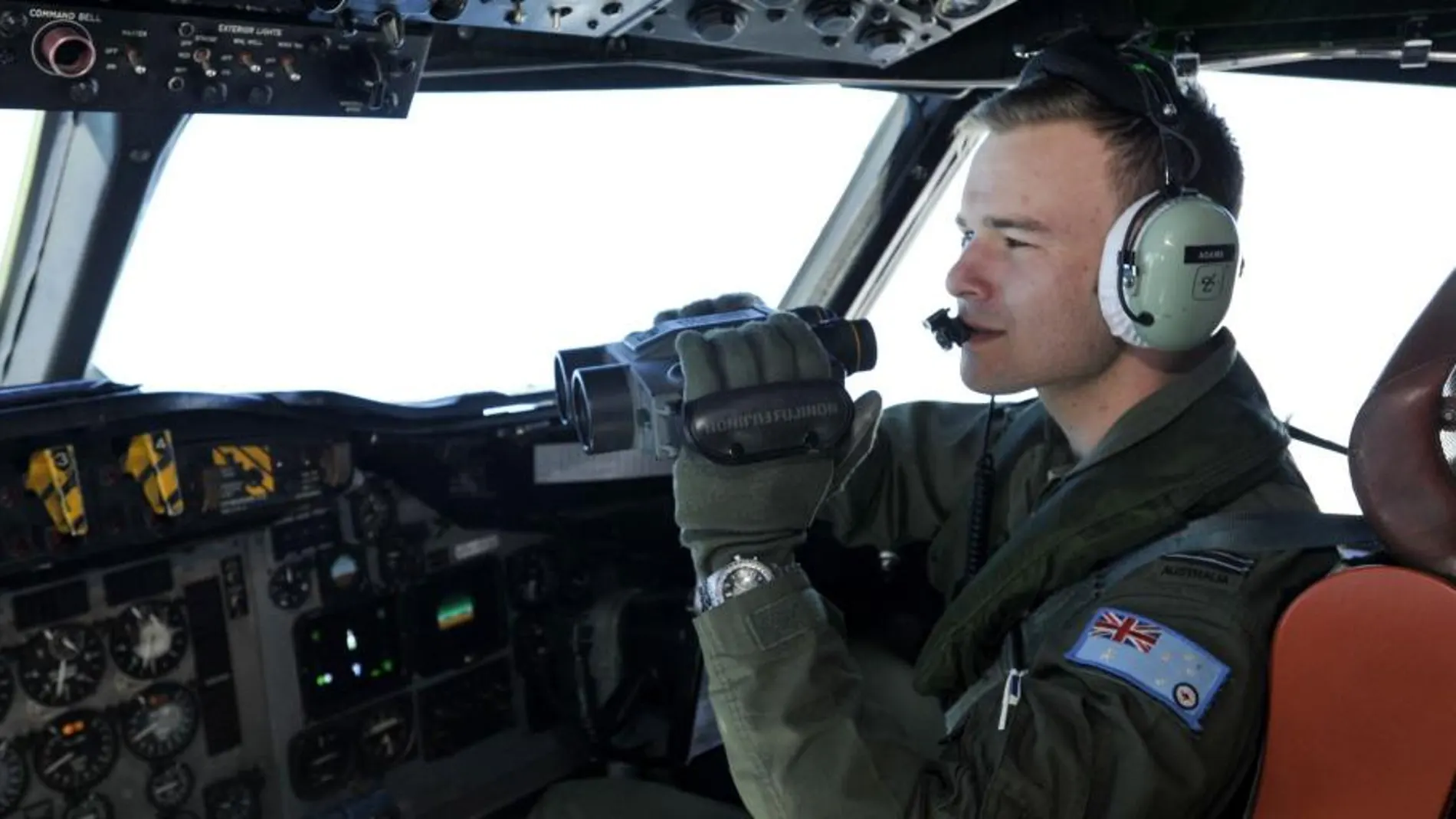 Un soldado de la Real Fuerza Aérea Australiana utiliza unos prismáticos desde un avión AP-3C Orion durante otra jornada de búsqueda del avión malasio desaparecido.