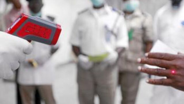 Sanitarios nigerianos toman la temperatura en el aeropuerto de Lagos a los viajeros recién llegados