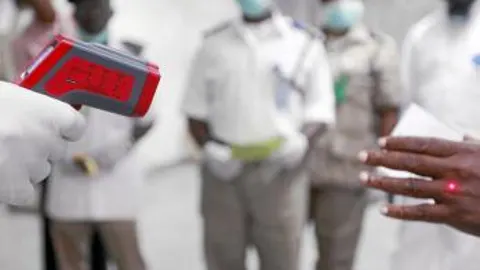 Sanitarios nigerianos toman la temperatura en el aeropuerto de Lagos a los viajeros recién llegados