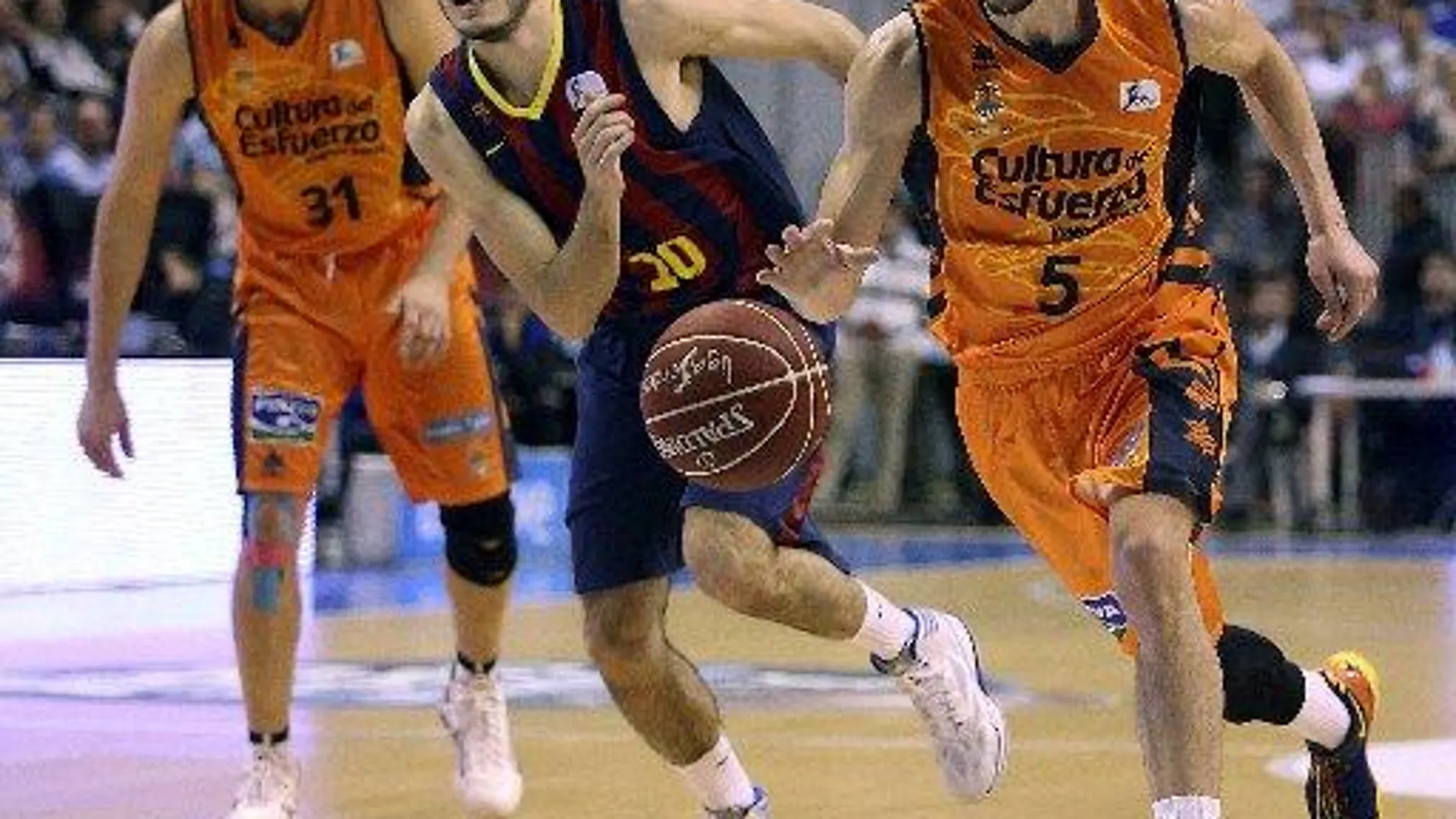 El ala-pivot del Valencia Basket, Pau Rivas (d), bota el balón ante el alero del F. C. Barcelona, Alex Abrines