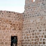 Un hombre entra en un cubo en la muralla de Urueña, que estaba oculto por un antiguo pajar adosado