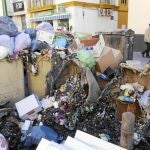 Arriba, aspecto que presenta una zona de recogida de residuos en la Alameda de Hércules.