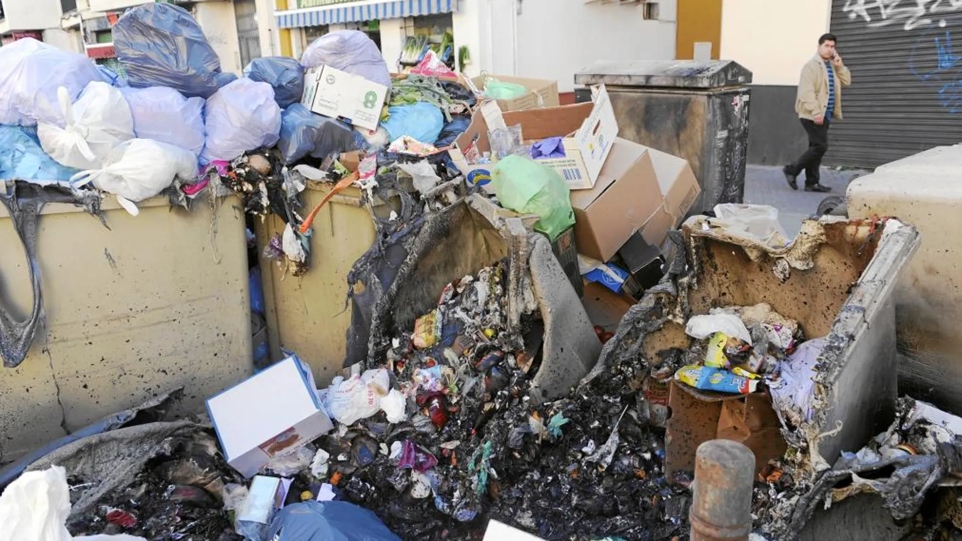 Arriba, aspecto que presenta una zona de recogida de residuos en la Alameda de Hércules.