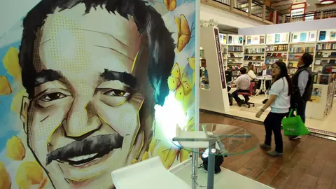 Una pareja pasa frente a una ilustración del nobel colombiano Gabriel García Márquez en la 28 edición de la Feria Internacional del Libro de Bogotá (Colombia).