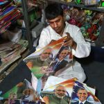Un tendero prepara banderines con los retratos del primer ministro, Narendra Modi, y el presidente estadounidense, Barack Obama