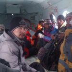 Montañeros y sherpas en un helicóptero en el que fueron restacados