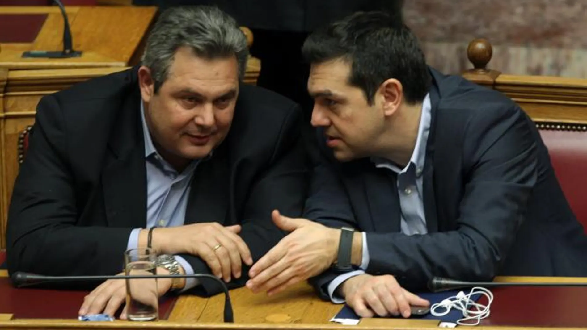 El primer ministro Alexis Tsipras (d) habla con el ministro de defensa y líder del Partido Independiente Panos Kammenos