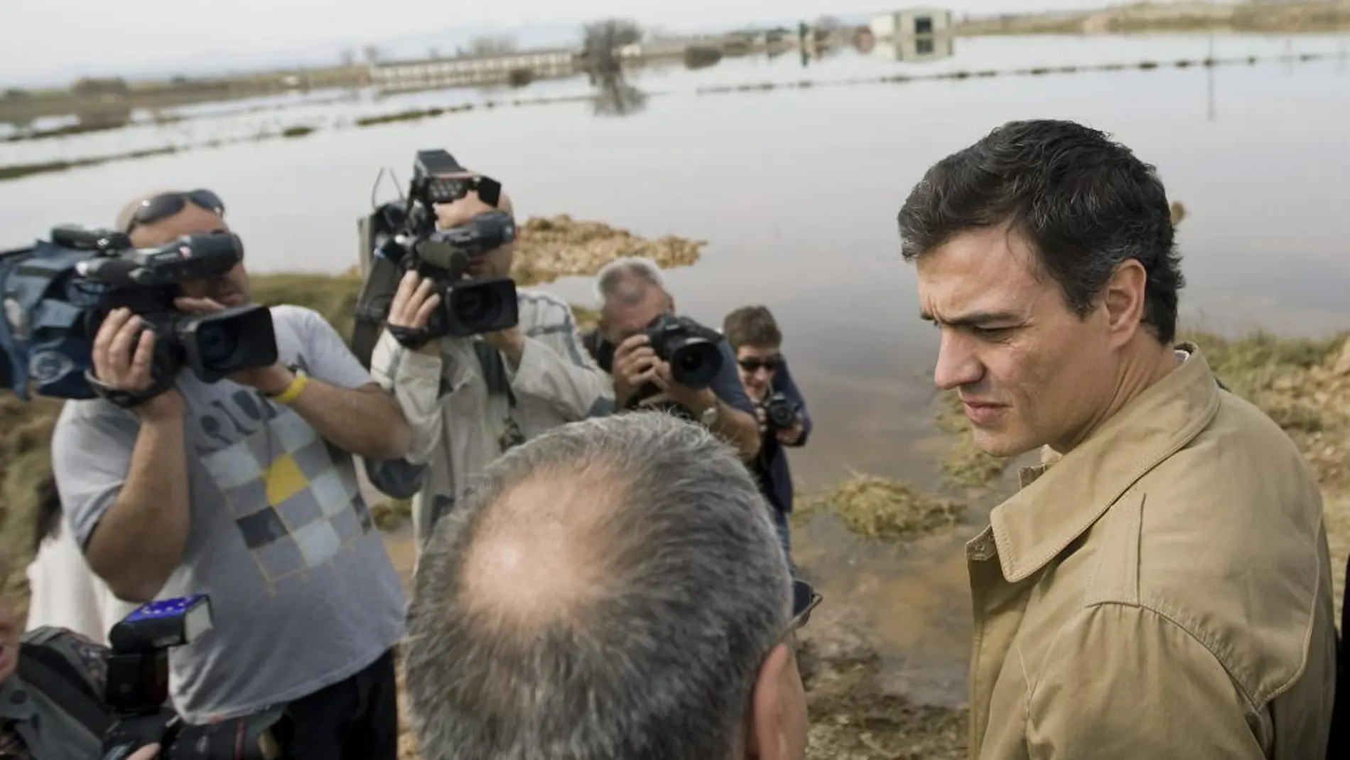 El secretario general del PSOE, Pedro Sánchez (d), junto al alcalde de Boquiñeni, Miguel Ángel Sanjuán (i), durante la visita que ha realizado hoy una de las zonas más afectadas por la crecida del Ebro