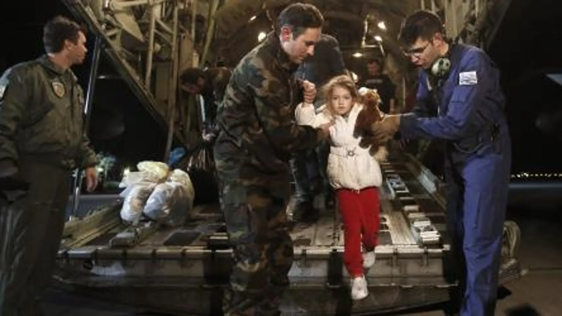 Los servicios de rescate ayudan a una niña a bajar de un avión.