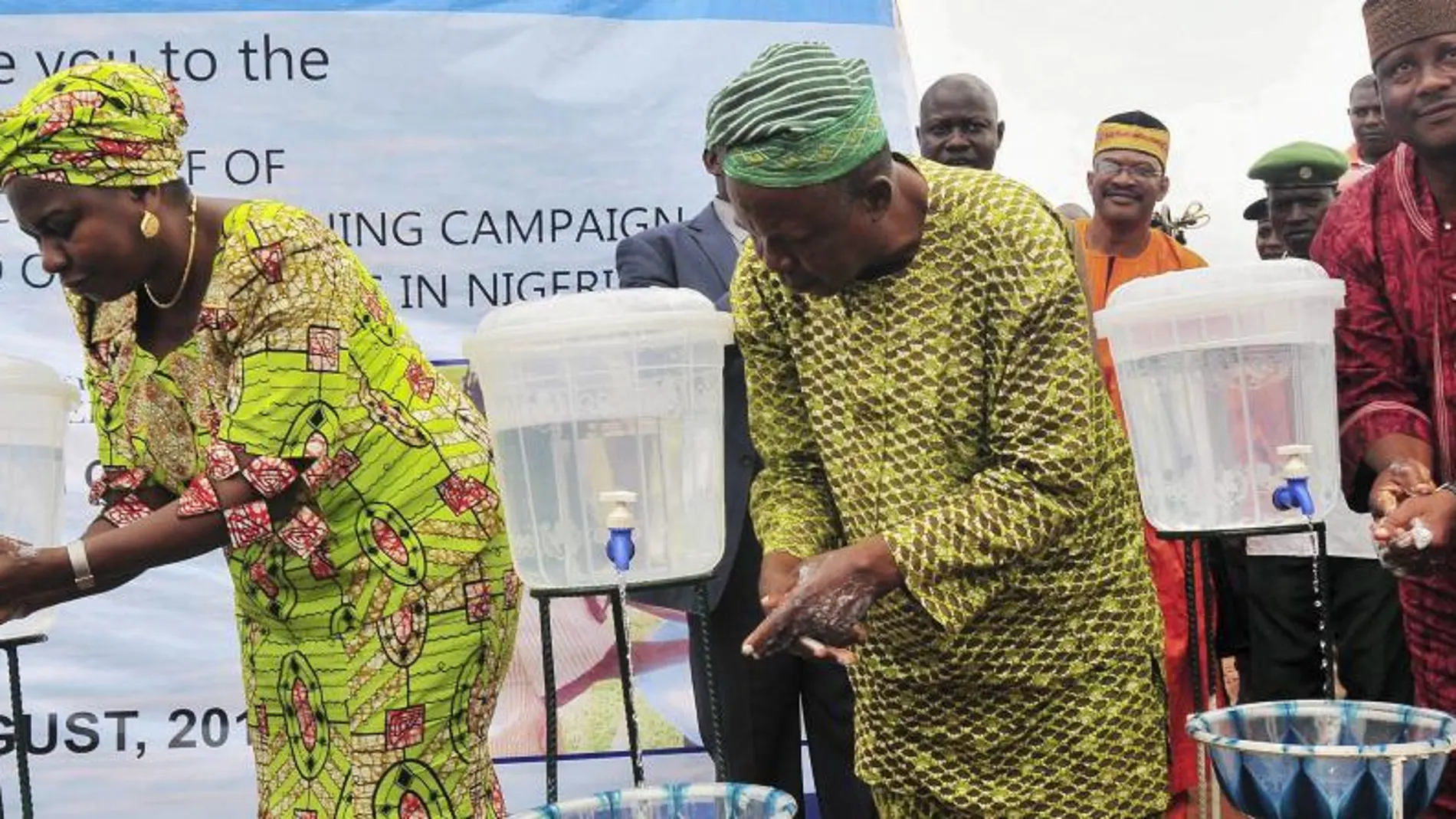 La ministra nigeriana de Recursos del Agua, Sarah Ochee (i), se lava las manos en compañía de otros dignatarios como parte de una campaña nacional de emergencia para combatir el virus del Ébola
