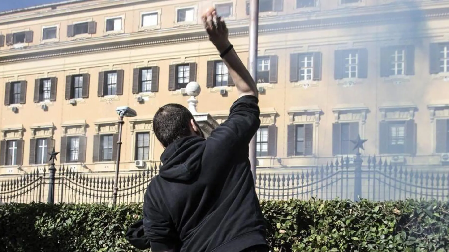 Varios manisfestantes lanzan huevos y dispositivos pirotécnicos durante una protesta ante el Ministerio de Economía en Roma.