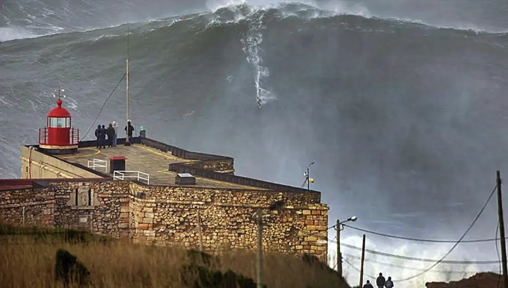 El surfista hawaiano Garrett McNamara (c) coge una ola gigante en la playa de Nazare, Portugal hoy, martes 29 de enero de 2013. Según informes locales, tras haber surfeado esta ola, McNamara ha batido su propio récord mundial. EFE/To Mane