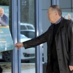 Un kazajo se detiene ante un cartel electoral del actual presidente y candidato a la reelección, Nursultán Nazarbáyev, en Astaná