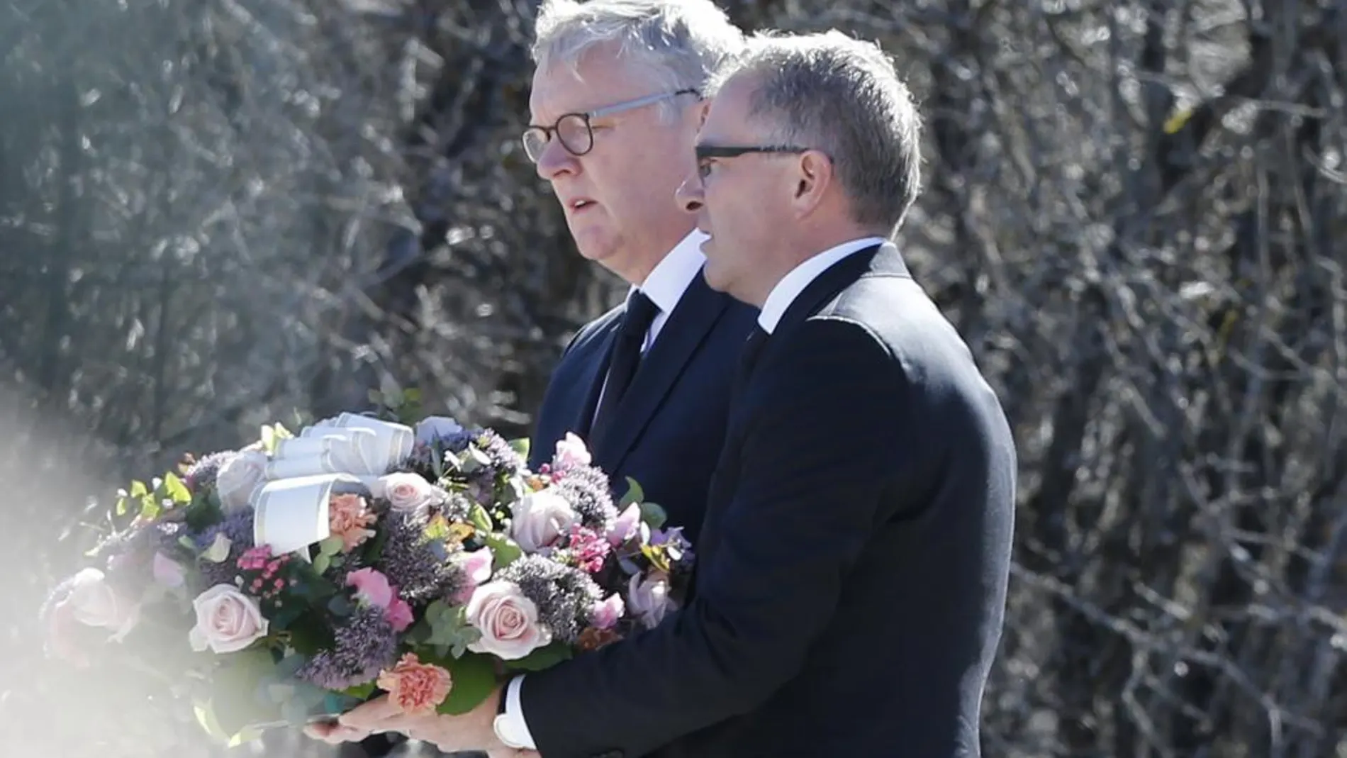 Los presidente de Germanwings, Thomas Winkelmann, y Lufthansa, Carsten Spohr, depositan un ramo de flores en el monolito de homenaje a las víctimas