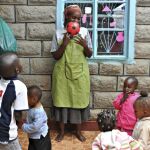 Consolata Mary Achieng juega con los niños de la guardería en la que trabaja, en el barrio chabolista de Dandora en Nairobi