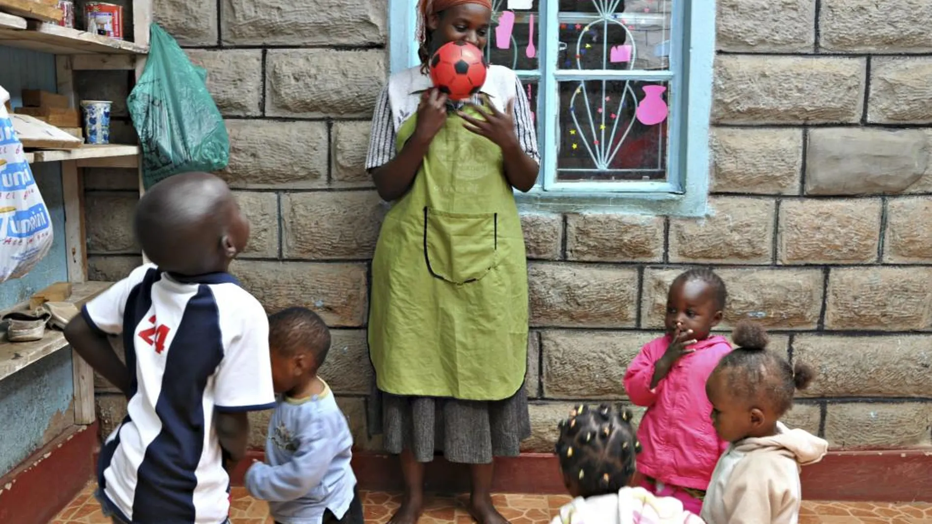 Consolata Mary Achieng juega con los niños de la guardería en la que trabaja, en el barrio chabolista de Dandora en Nairobi