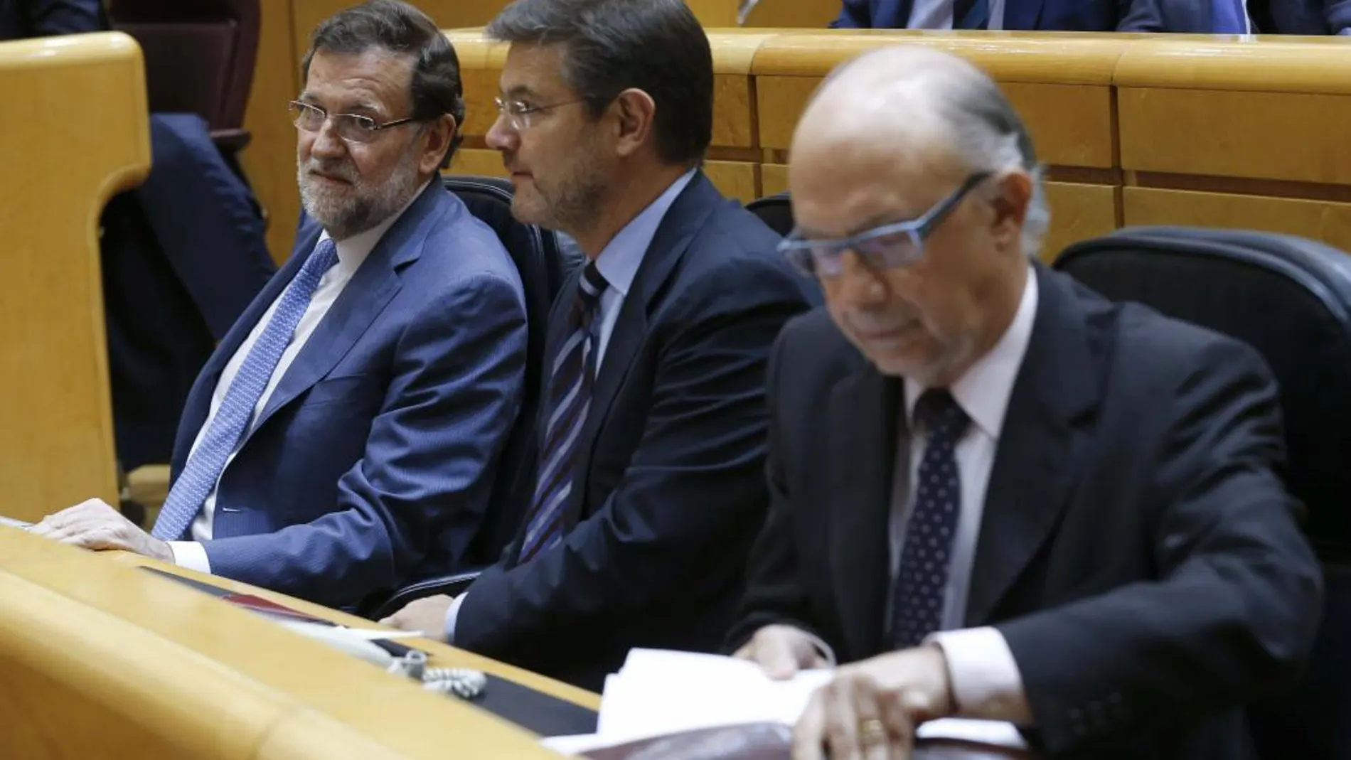 El presidente del Gobierno, Mariano Rajoy, junto a los ministros de Justicia, Rafael Catalá, y Hacienda, Cristóbal Montoro
