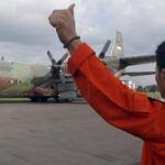 Un soldado de la Fuerza Aérea indonesia hace señales a la tripulación a bordo de un avión Hércules C-130 durante las labores de búsqueda del avión de pasajeros de AirAsia.