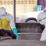 Enfermeros del hospital ELWA de Monrovia recogen a un paciente en la sala de espera
