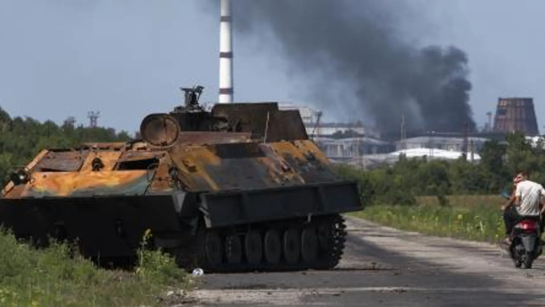 Unos curiosos observan el estado de un tanque prorruso totalmente destrozado tras el ataque las tropas ucranianas.