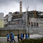 Trabajadores ucranianos caminan cerca de la central nuclear de Chernóbil, Ucrania, el martes 21 de abril de 2015