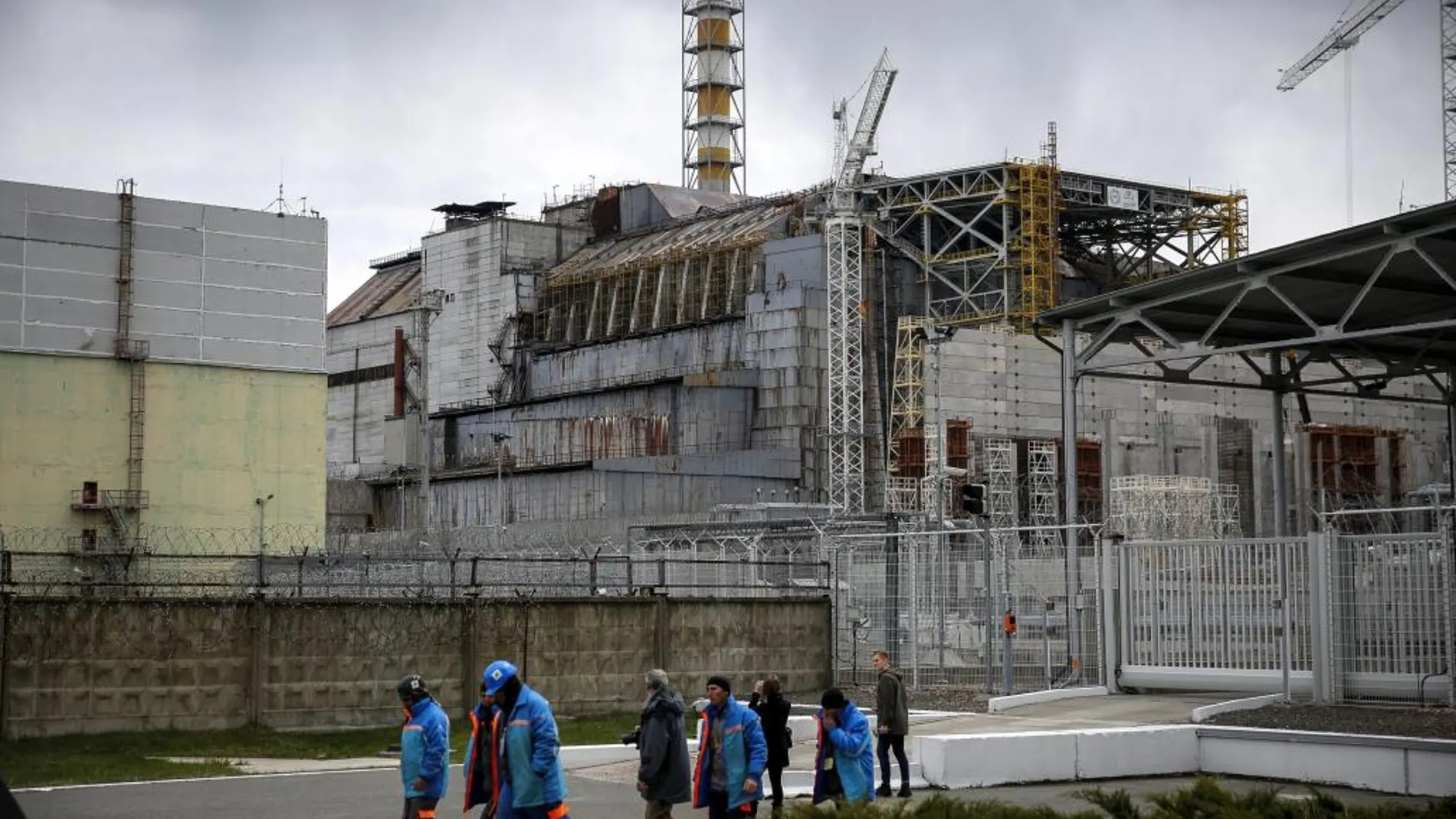 Trabajadores ucranianos caminan cerca de la central nuclear de Chernóbil, Ucrania, el martes 21 de abril de 2015