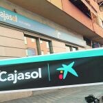 Unos operarios cambian el antiguo rótulo de Cajasol