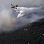 Un avión trabajando en la extinción del incendio declarado en el paraje del Río de la Miel, en Algeciras (Cádiz).