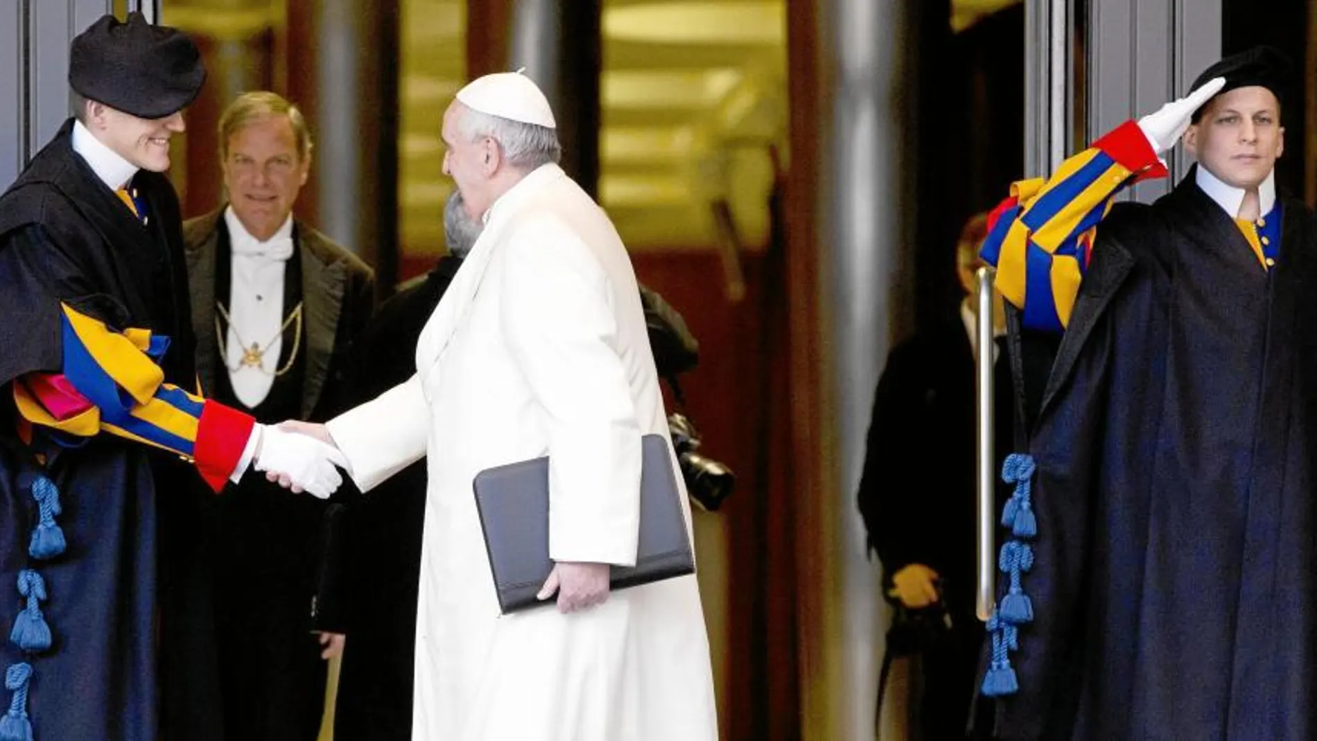 Francisco saluda a un miembro de la Guardia Suiza en su entrada a la primera jornada del consistorio extraordinario de cardenales