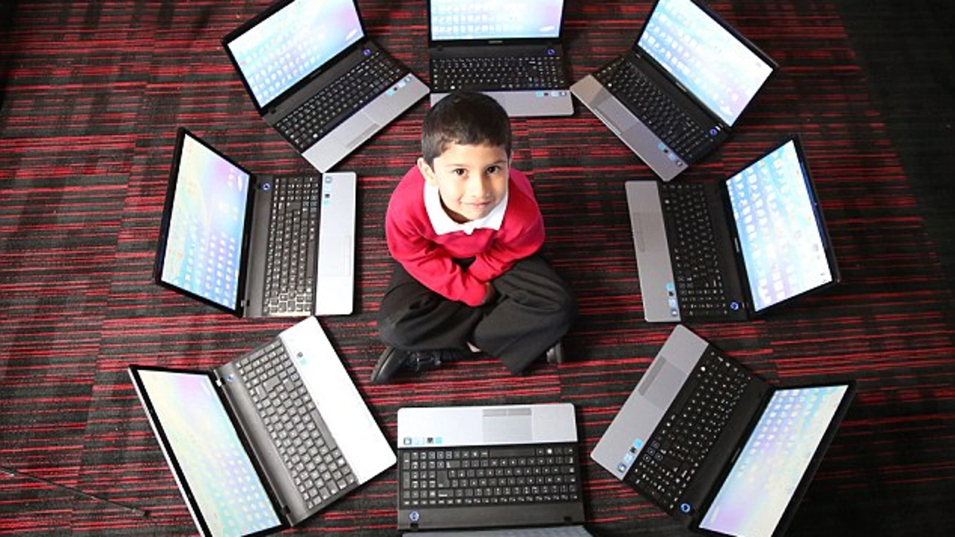 Ayan rodeado de varios ordenadores portátiles