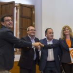 Los representantes del PSOE Mario Jiménez (i) y Juan Cornejo (2i), y de Ciudadanos Manuel Luzón (2d) e Irene Rivera (d), juntan sus manos tras firmar un acuerdo que permitirá la investidura de Susana Díaz.