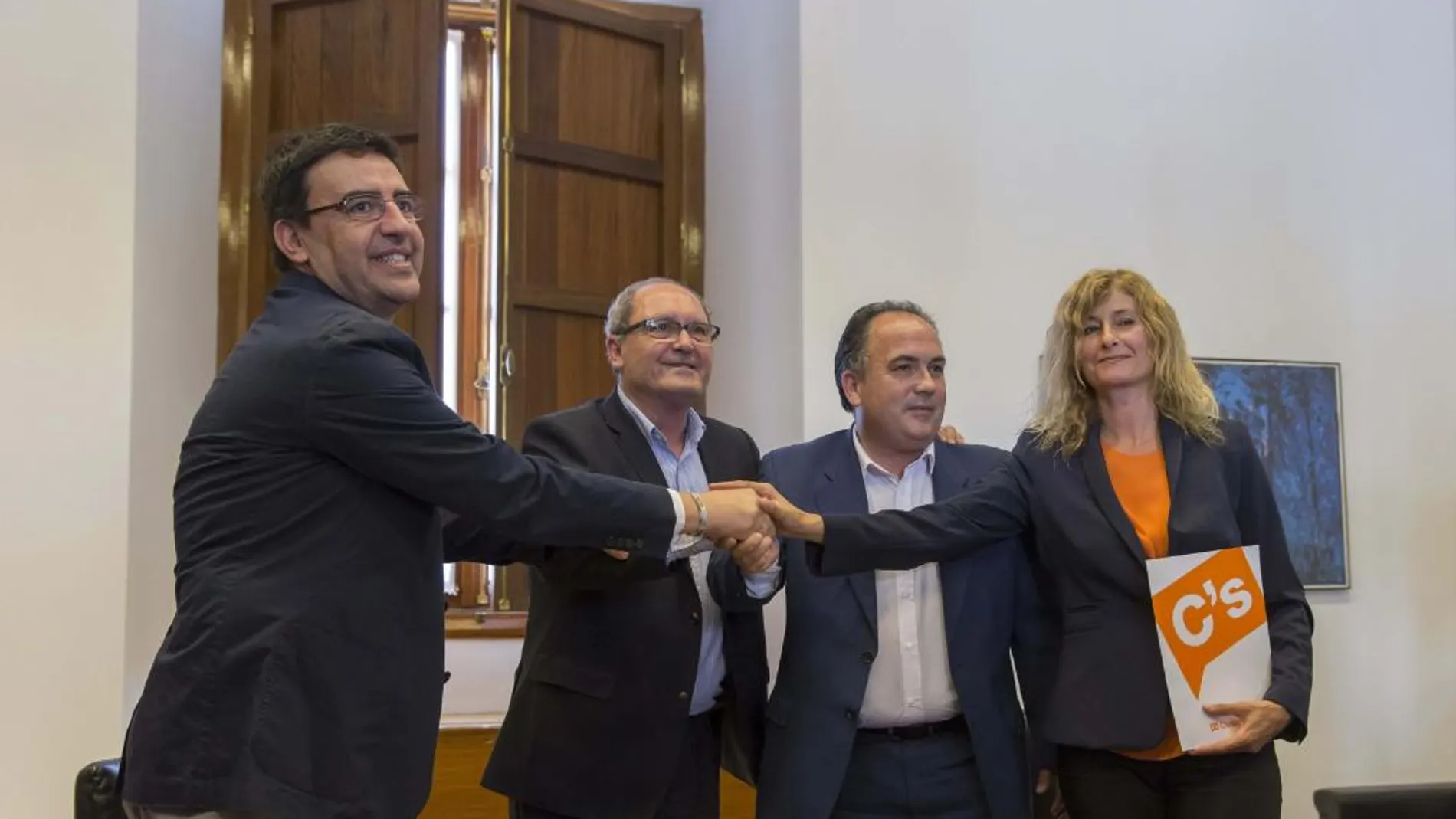 Los representantes del PSOE Mario Jiménez (i) y Juan Cornejo (2i), y de Ciudadanos Manuel Luzón (2d) e Irene Rivera (d), juntan sus manos tras firmar un acuerdo que permitirá la investidura de Susana Díaz.
