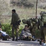 Soldados israelíes reciben atención médica de varios compañeros después de que impactara un misil antitanques en su vehículo cerca de la zona de Har Dov